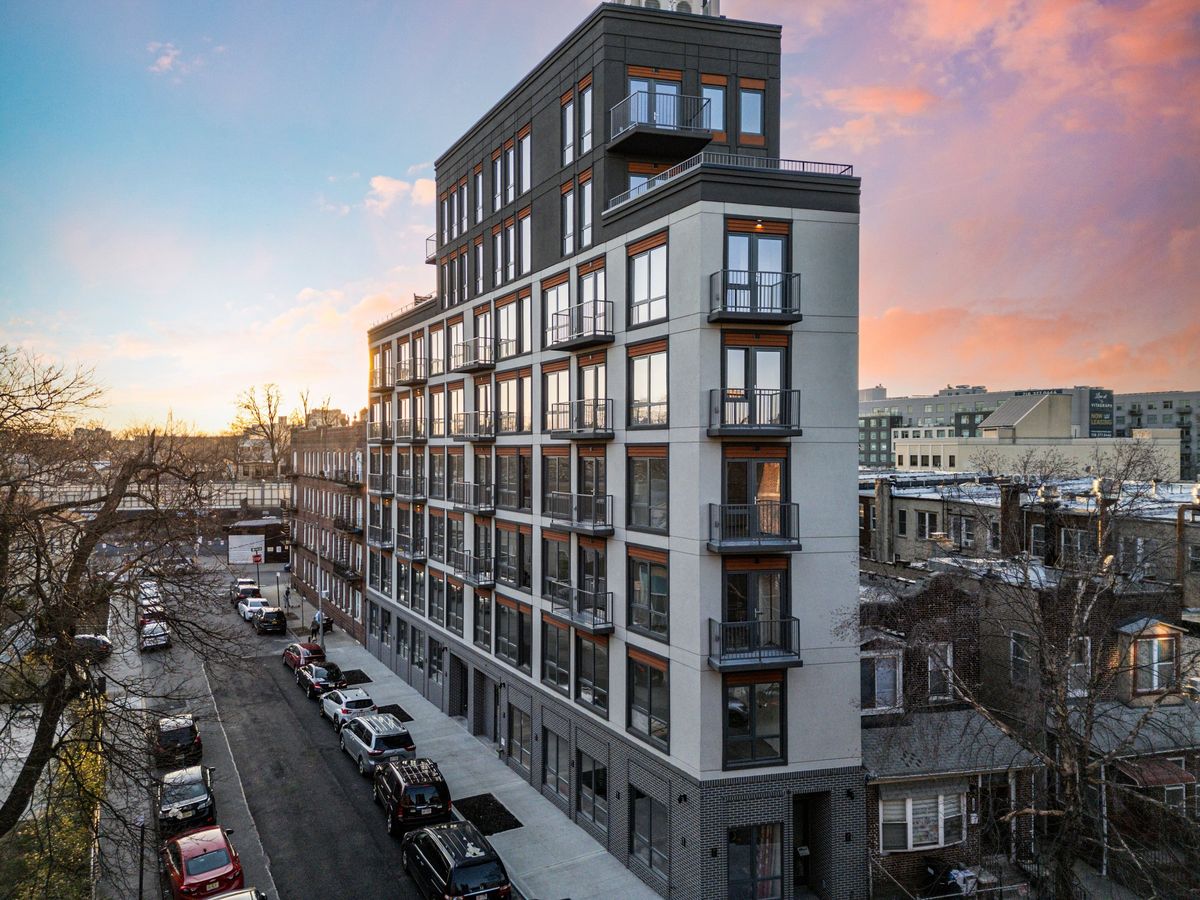 A mid-rise apartment building with Vistaza windows, at dusk